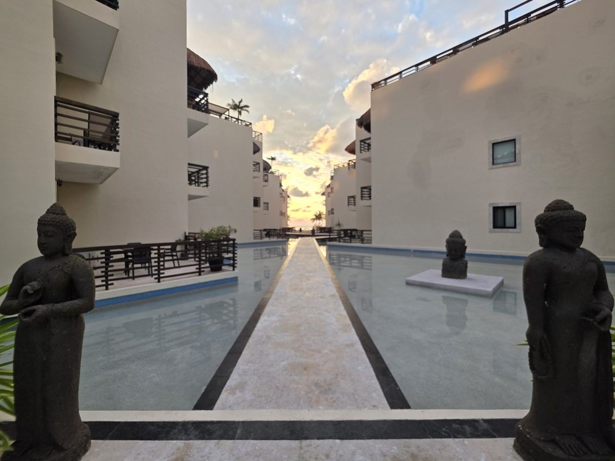 Standing stone Buddhas flanking the Mirror Pool walkway at sunrise