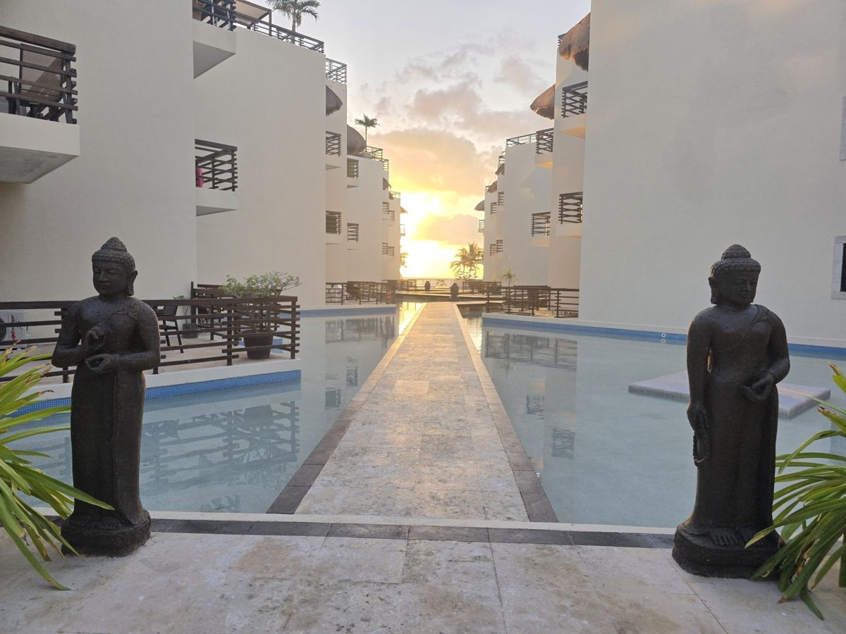 The Mirror Pool at first light, its walkway running between the towers to the great palapa
